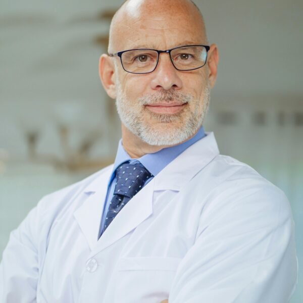 Portrait of a confident male scientist in a laboratory setting wearing a white coat.