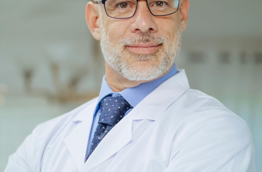 Portrait of a confident male scientist in a laboratory setting wearing a white coat.