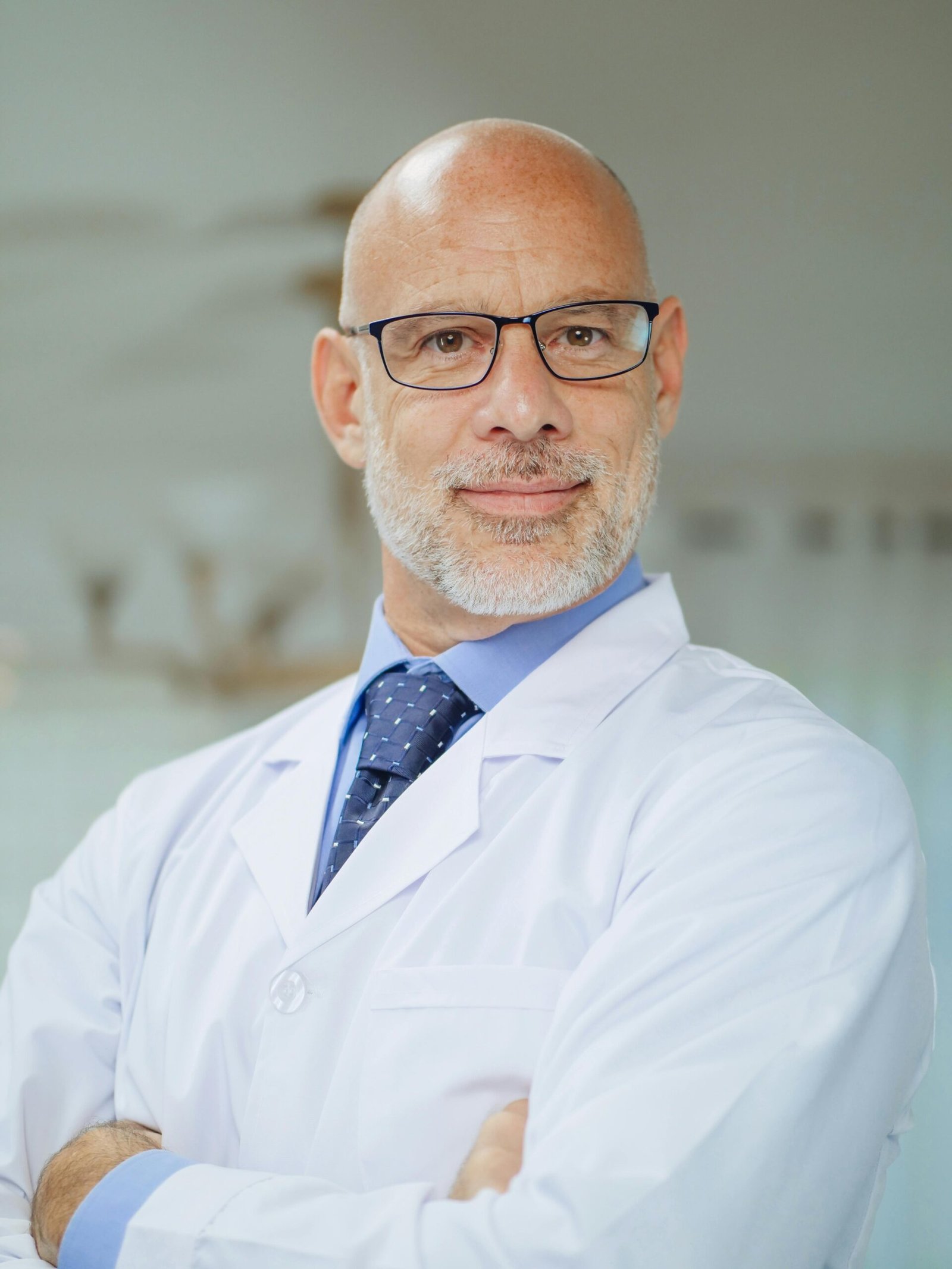 Portrait of a confident male scientist in a laboratory setting wearing a white coat.