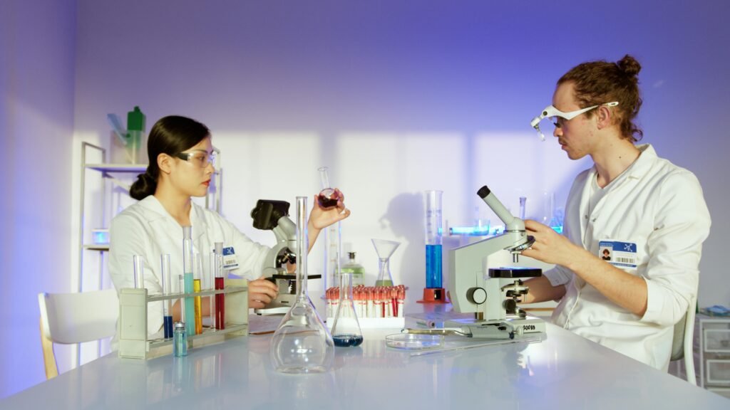 Two scientists working in a well-equipped laboratory conducting chemical research and experiments.