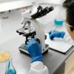 Scientist using a microscope to analyze samples in a modern laboratory environment.