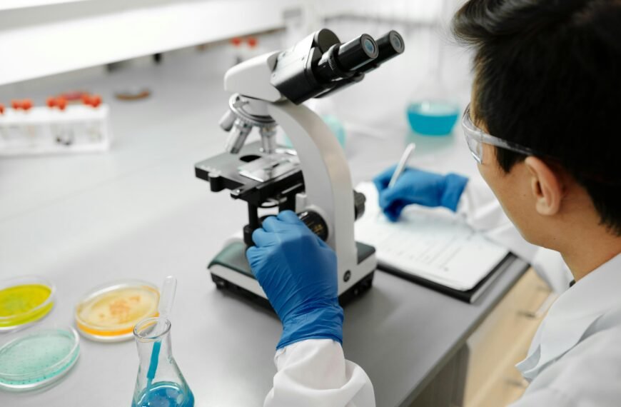 Scientist using a microscope to analyze samples in a modern laboratory environment.