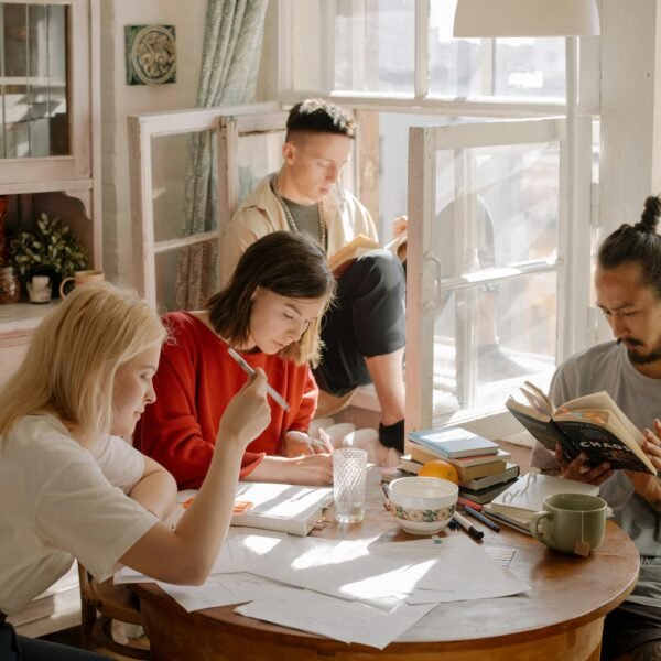 A group of college students studying in a bright, cozy room with natural light.