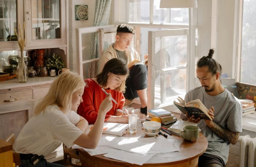 A group of college students studying in a bright, cozy room with natural light.