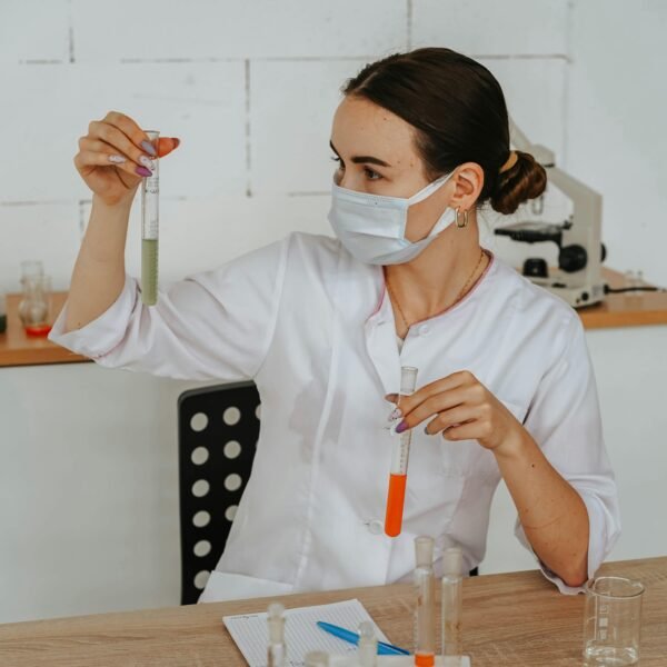 A female scientist carefully examines test tubes in a laboratory setting, showcasing scientific research and discovery.