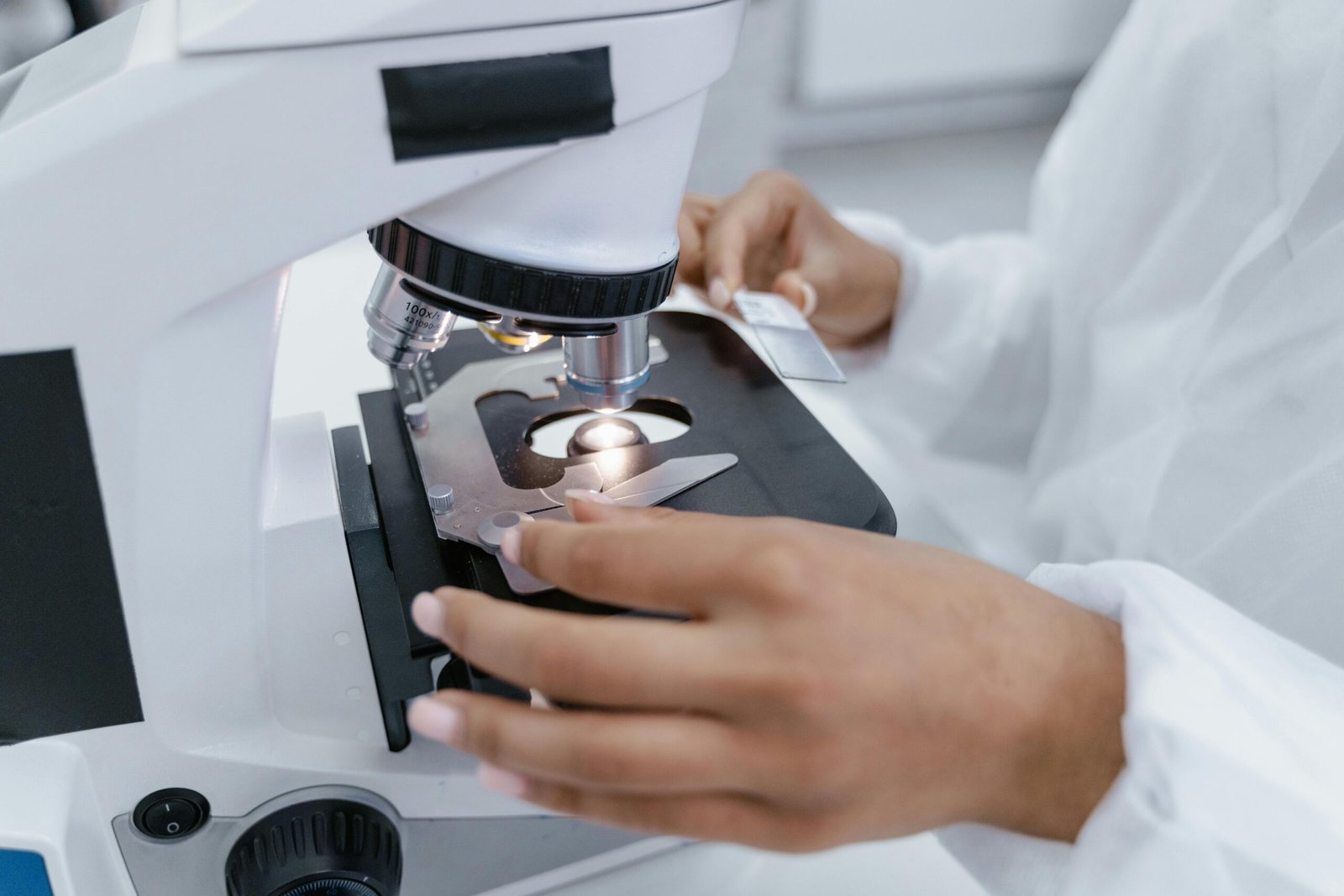 Scientist in laboratory using a microscope for detailed sample analysis.